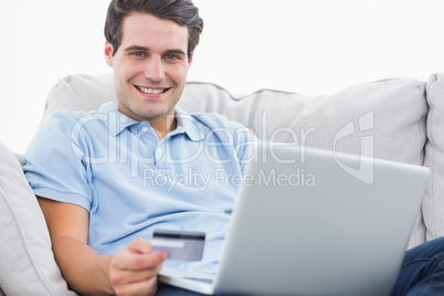 Portrait of a man using his credit card to purchase online