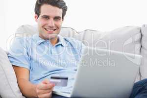 Portrait of a man using his credit card to purchase online