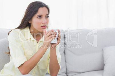 Thoughtful woman holding a cup of coffee