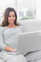 Woman relaxing and using her laptop