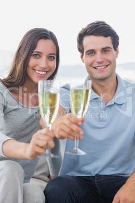 Portrait of a couple toasting their flutes of champagne
