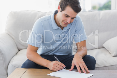 Handsome man writing on a paper