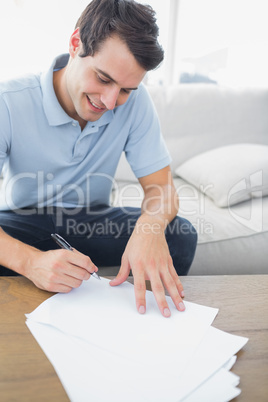 Cheerful man writing on a paper