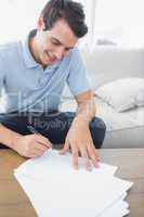 Cheerful man writing on a paper