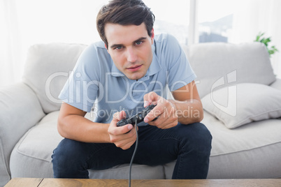 Man playing video games while he is sat on a sofa