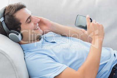 Cheerful man enjoying music with his smartphone