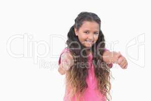 Smiling little girl does thumbs up at camera