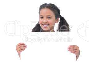Smiling little girl holding and presenting sign at camera