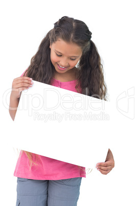 Little girl holding and looking at sign