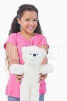 Smiling little girl showing her teddy bear to camera