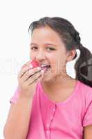 Smiling little girl eating apple