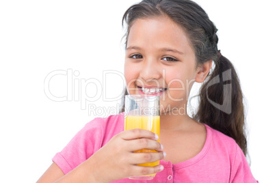 Smiling little girl drinking orange juice