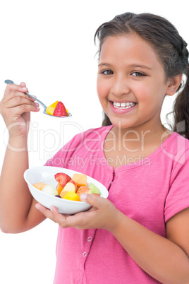 Happy little girl eating fruit salad