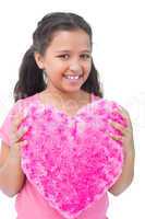 Little girl holding cushion in the shape of a heart