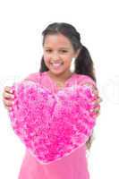 Little girl showing cushion in the shape of a heart