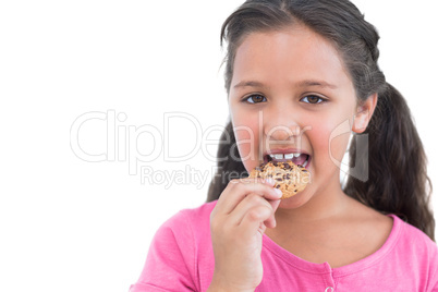 Happy little girl eating a cookie