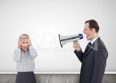 Businessman shouting with a megaphone at his colleague