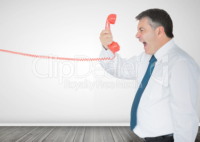 Businessman holding a phone and screaming