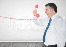 Businessman holding a phone and screaming