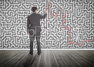 Businessman tracing a red line on a maze