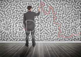 Businessman tracing a red line on a maze