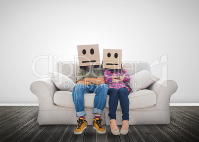 Couple sitting on couch with cardboard boxes over their head