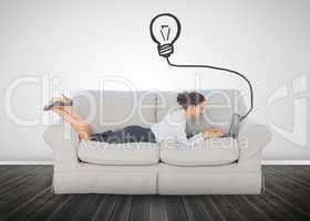 Attractive businesswoman lying on a couch and typing on her lapt