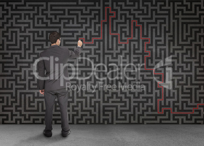 Rear view of a businessman writing a red line through black maze