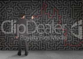Rear view of a businessman writing a red line through black maze