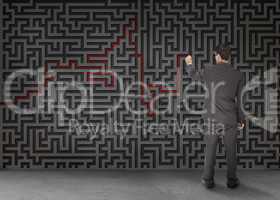 Rear view of a businessman drawing a red line through black maze