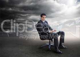Attractive businessman using his laptop outside during stormy we