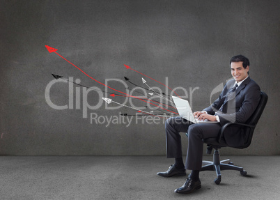 Businessman using his laptop arrows coming from it