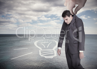 Giant hand dropping off a businessman on a surface