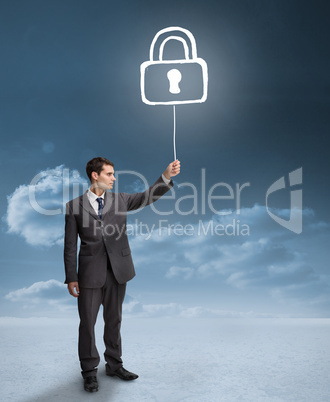 Businessman holding a floating padlock