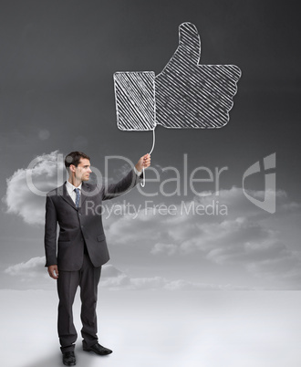 Businessman holding a giant thumb up