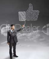Businessman holding a giant thumb up