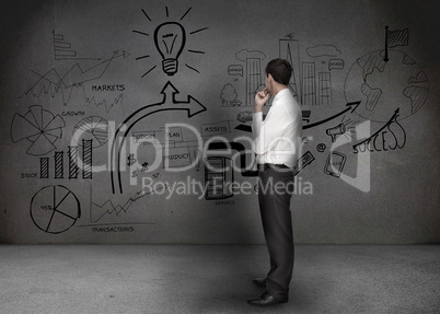 Businessman looking at a wall with drawings
