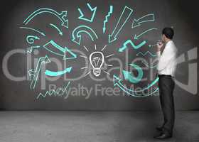 Businessman looking at a wall with drawings of arrows