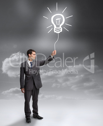 Businessman holding a drawing of a light bulb