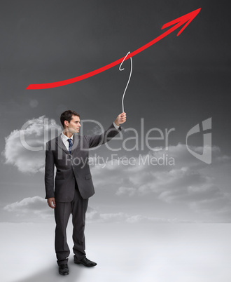 Businessman holding a drawing of a red arrow