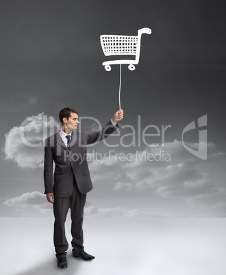 Businessman holding a drawing of a shopping cart