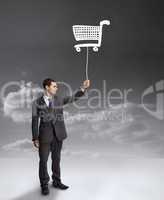 Businessman holding a drawing of a shopping cart