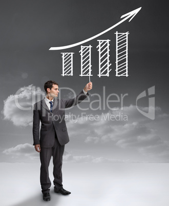 Handsome businessman holding a drawing of a growing chart