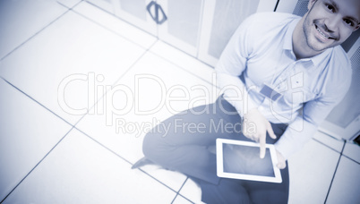 Handsome man sitting and using a tablet