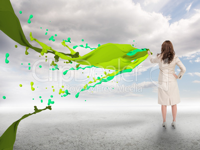 Creative businesswoman with green paint splash