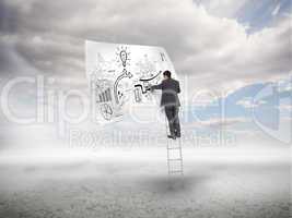Businessman on a ladder sketching on a paper