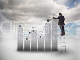 Businessman standing on a ladder drawing a chart