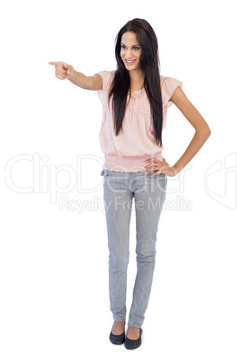 Smiling young woman pointing at something