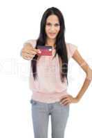 Brunette showing her credit card to camera