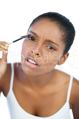 Beautiful woman putting mascara on her eyelash